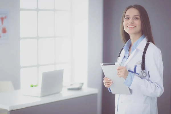 Женщина-врач, использующая планшетный компьютер в холле больницы — стоковое фото