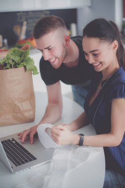 Çift evde mutfak içinde laptop ile onların fatura ödeme