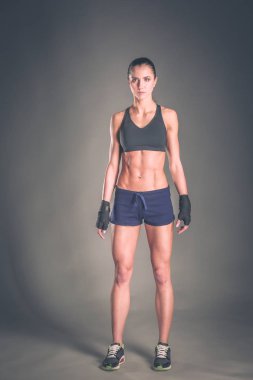 Spor giyim siyah arka plan karşı poz kas genç kadın.