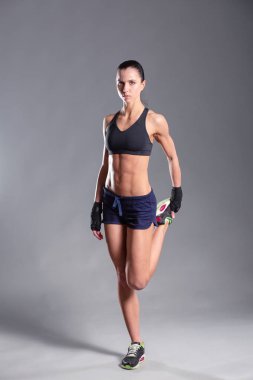 Spor giyim siyah arka plan karşı poz kas genç kadın.