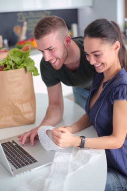 Çift evde mutfak içinde laptop ile onların fatura ödeme