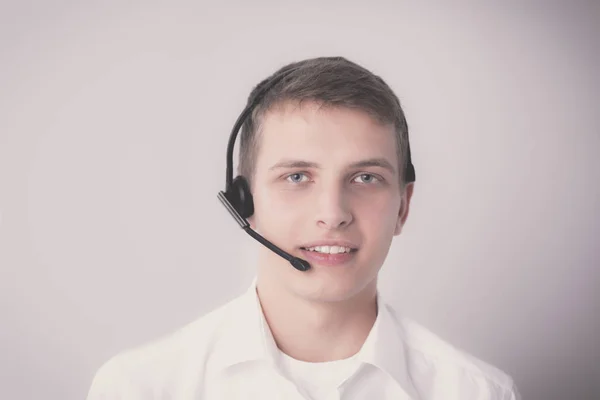 Retrato de un joven sonriendo sentado sobre un fondo gris. Retrato del joven — Foto de Stock