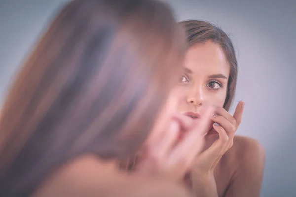Attractive young woman applying cream on her Face — Stock Photo, Image