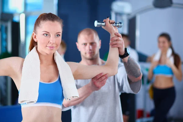 Beautiful woman at the gym exercising with her trainer. Beautiful woman. Gym — Stock Photo, Image