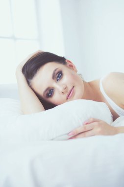 Genç ve güzel bir kadın yatakta yatıyor..