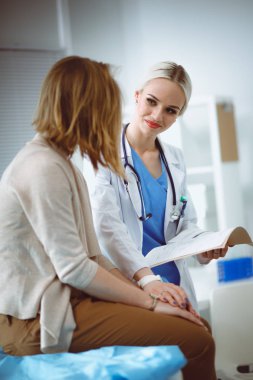 Doktor ve hasta masada otururken bir şey tartışıyorlar. Tıp ve sağlık hizmetleri kavramı. Doktor ve hasta.