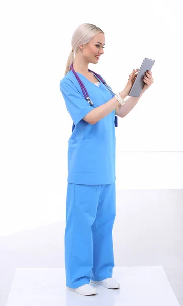 Médico femenino usando una tableta digital y de pie sobre fondo blanco. Mujeres doctores. — Foto de Stock