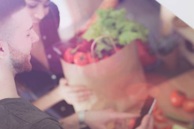 Mutlu çift Smartphone ayakta mutfakta kullanarak