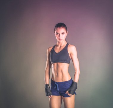 Spor giyim siyah arka plan karşı poz kas genç kadın.