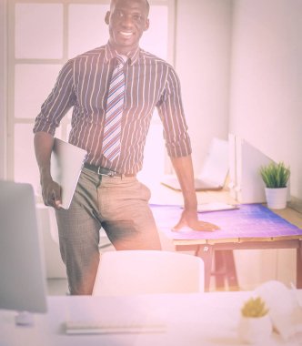 Ofiste bilgisayar ve planlarla çalışan Afrikalı Amerikalı bir mimar.