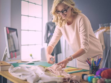 Moda tasarımcısı kadın stüdyoda tasarımları üzerinde çalışıyor..