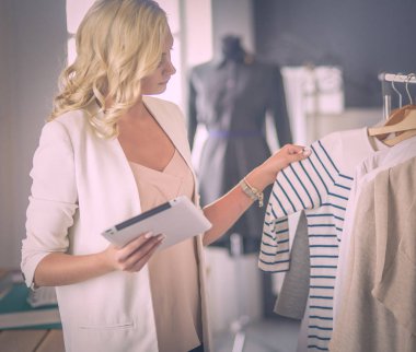 Moda tasarımcısı kadın stüdyoda tasarımları üzerinde çalışıyor..