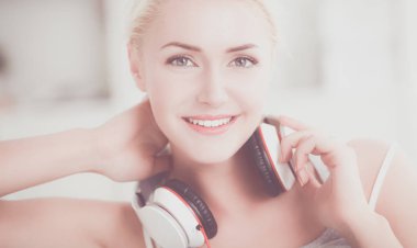 Evdeki genç ve güzel kadın kanepede oturup müzik dinliyor.