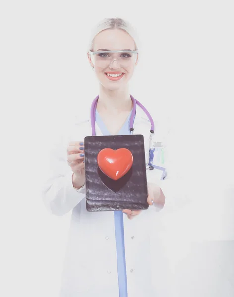 Ung kvinna läkare håller ett rött hjärta, isolerad på vit bakgrund. Kvinnlig läkare — Stockfoto