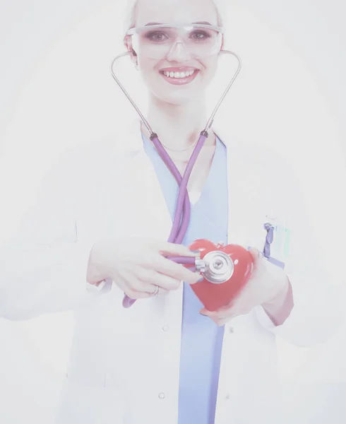 Médica jovem segurando um coração vermelho, isolado em fundo branco. Mulher médica — Fotografia de Stock