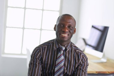 Ofiste oturan bir yakışıklı siyah işadamı portresi