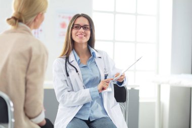 Doktor ve hasta masada otururken bir şey tartışıyorlar. İlaç ve sağlık hizmetleri kavramı