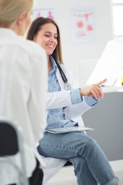 Doktor ve hasta masada otururken bir şey tartışıyorlar. İlaç ve sağlık hizmetleri kavramı