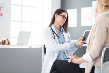 Doktor ve hasta masada otururken bir şey tartışıyorlar. İlaç ve sağlık hizmetleri kavramı