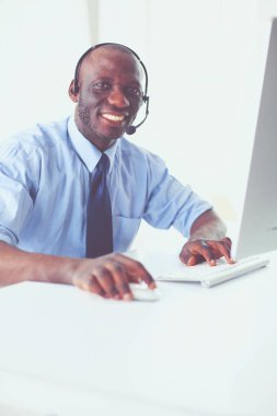 Kulaklıklı Afro-Amerikan işadamı laptopuyla çalışıyor.