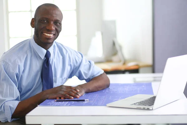 Афроамериканський архітектор, що працює з комп'ютером і кресленнями в офісі — стокове фото