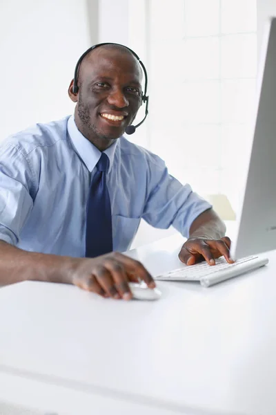 African american businessman on headset working on his laptop — Stock Photo, Image