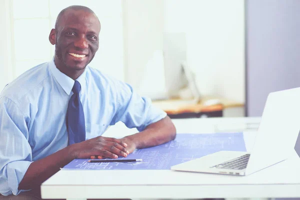 Arquitecto afroamericano trabajando con computadoras y planos en la oficina —  Fotos de Stock