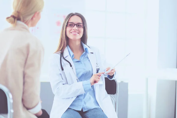 Médico e paciente discutindo algo enquanto se senta na mesa. Conceito de medicina e cuidados de saúde — Fotografia de Stock