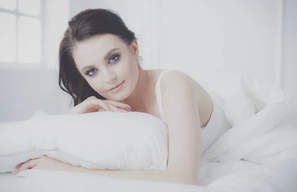 Молода красива жінка лежить в ліжку . — стокове фото