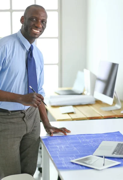 Arquitecto afroamericano trabajando con computadoras y planos en la oficina — Foto de Stock