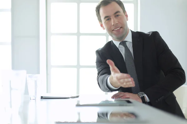 Porträt eines jungen Mannes, der an seinem Schreibtisch im Büro sitzt. — Stockfoto