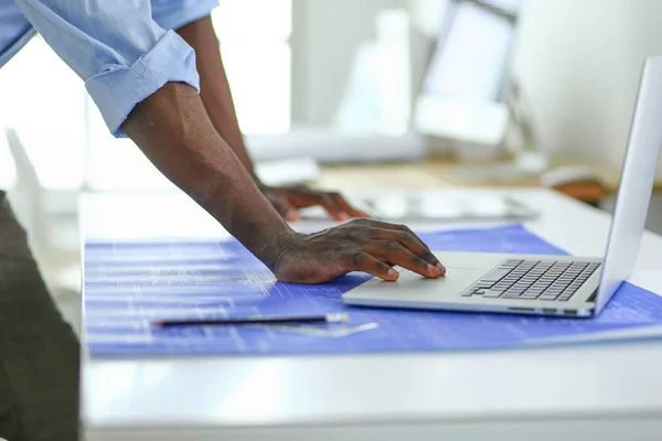 アフリカ系アメリカ人の建築家がオフィスでコンピュータと設計図を使って — ストック写真