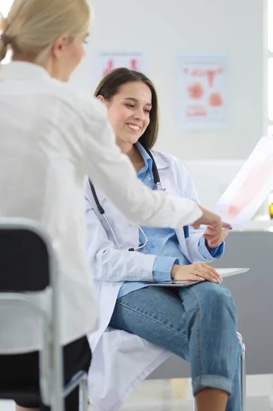 Doktorn och patienten diskuterar något när de sitter vid bordet. Medicin och hälsovård — Stockfoto