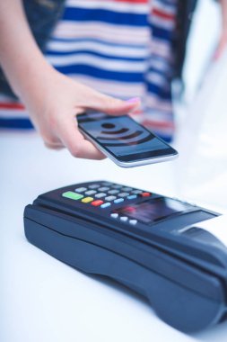 Müşteri ile smartphone Nfc teknolojisi kullanılarak dükkanda ödüyor. NFC teknolojisi. Müşteri ödeme