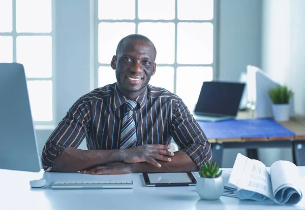 Beau Afro-Américain homme d'affaires en costume classique utilise un ordinateur portable et souriant tout en travaillant au bureau — Photo