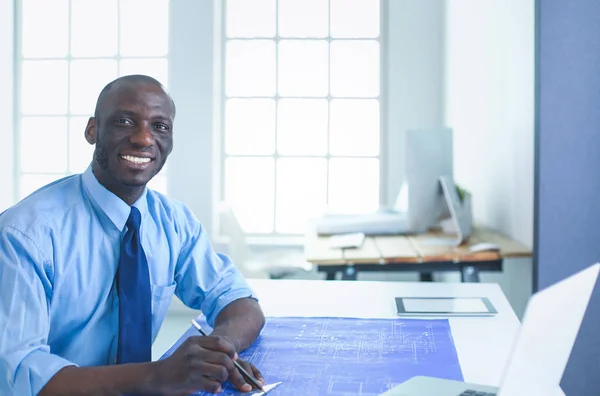 Arquitecto afroamericano trabajando con computadoras y planos en la oficina — Foto de Stock