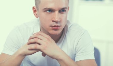 Genç adam sandalyede oturuyor.