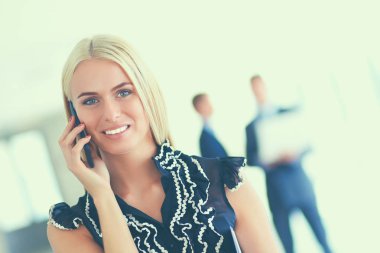 Ofiste cep telefonu kullanan güzel bir iş kadını.