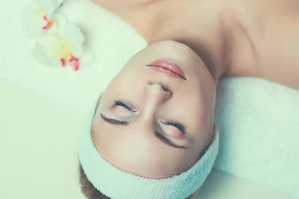 Güzel genç bir kadın masaj yaptırıyor, kuaförde yatıyor. — Stok fotoğraf
