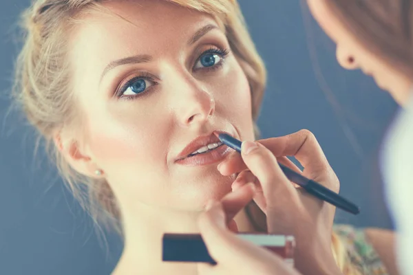 Kunstenaar doet professionele make-up van vrouw — Stockfoto