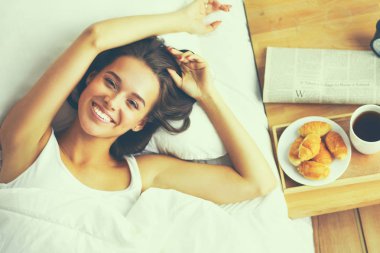 Evde yatakta yatan genç güzel kadın