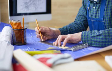 Ofisteki çizim masasında çalışan mimar