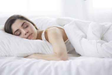 Güzel bir kadın yatağında uzanıyor.