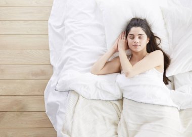 Güzel bir kadın yatağında uzanıyor.