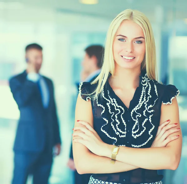 Affärskvinna som står i förgrunden i office — Stockfoto