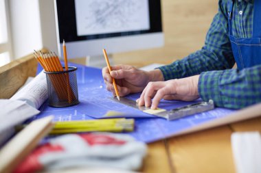 Ofisteki çizim masasında çalışan mimar