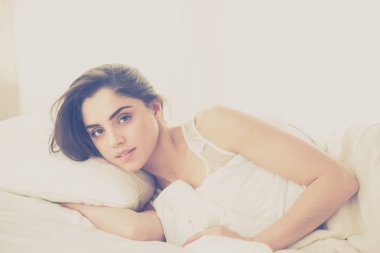 Güzel bir kadın yatağında uzanıyor.