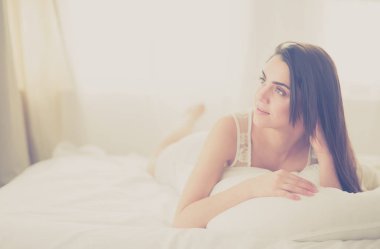 Güzel bir kadın yatağında uzanıyor.