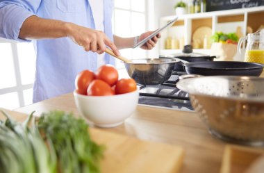 Adam ev mutfağında lezzetli ve sağlıklı yemekler hazırlıyor.