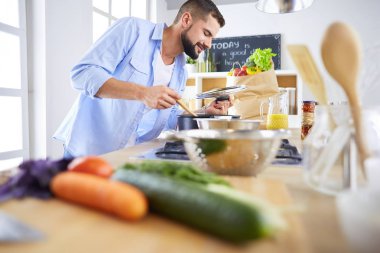 Adam ev mutfağında lezzetli ve sağlıklı yemekler hazırlıyor.